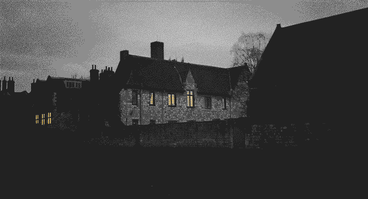 [PHOTO] A light shines through the window of an old stone building in York, England at dusk.